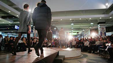 Models going down runway, man and woman showcasing designs, fashion show, models in spotlight