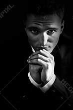 Sad man in the dark praying to God