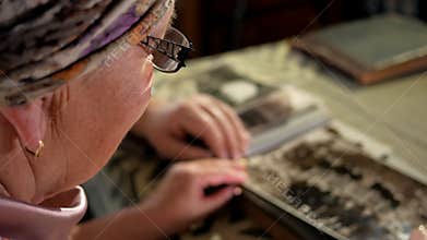 An elderly couple man and woman are looking at their old photos at home and talking. A man with a mustache, a wife with