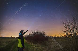 Man with flashlight observing night sky