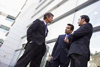 Group of businessmen talking outside office buildi