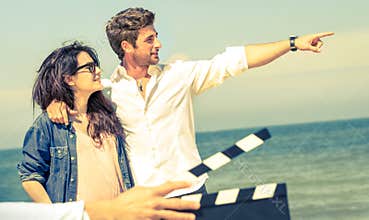 Young couple in love acting for romantic film at beach