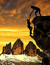 Silhouette of girls climbing on the rock.