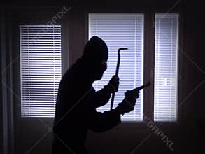 Sneaking burglar with gun and crowbar