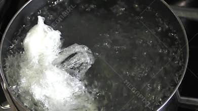 Using cling film to poach eggs in boiling water