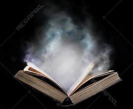 Ancient open book in the magical smoke