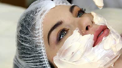 Applying facial mask at woman face