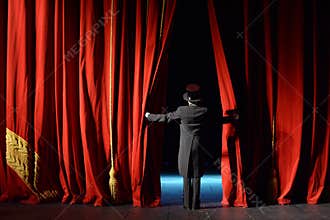 Actor in a tuxedo stage curtain opens