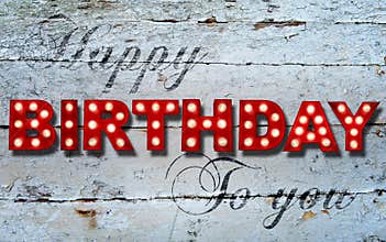 Glowing Happy Birthday on wooden background