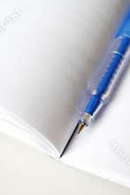 Blue pen on white open book