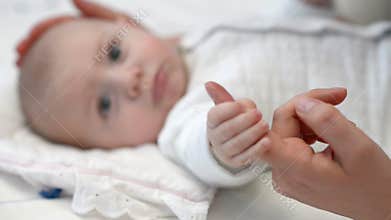 Baby holding mother's finger