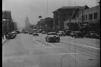 Car turning down street in downtown Los Angeles, 1940s