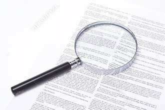 Magnifying glass lying on a legal contract