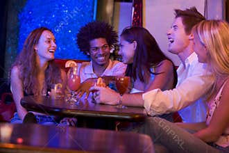 Group of young adults in a nightclub talking