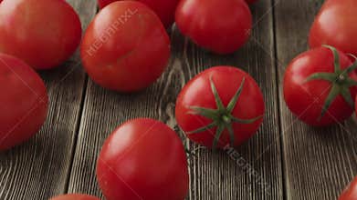 Tomatoes roll over the screen in slow motion