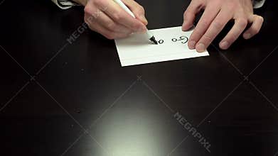 Hands writing the note go away