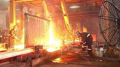 Workers cutting fiery steel blocks