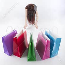 Woman Bowing on Floor In Front of Shopping Bags