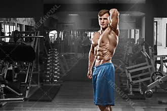 muscular man posing in gym, shaped abdominal. Strong male naked torso abs, working out
