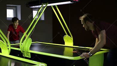 Friends playing air hockey game