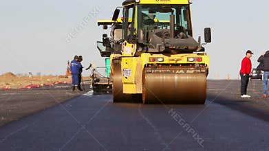 Road rollers leveling fresh asphalt pavement