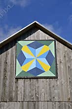 Barn quilt on old weathered building.