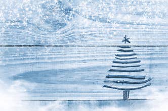 Christmas tree made from dry sticks on wooden, blue background. Snow and snow flaks image. Christmas tree ornament with star.