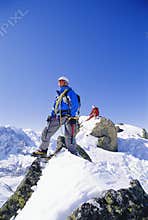 Young men mountain climbing on snowy peak