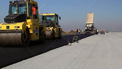 Road rollers leveling fresh asphalt pavement