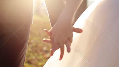 Newly married couple walk together holding hands