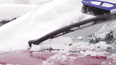 Owner cleans his car from the snow.