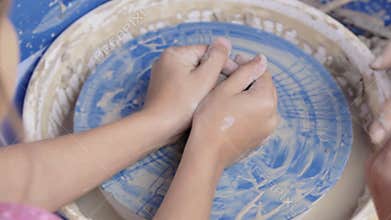 Potter teaches his craft to the children.