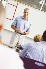 A teacher talks to school children in a classroom
