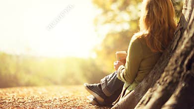 Anonymous woman enjoying takeaway coffee cup on sunny cold fall day