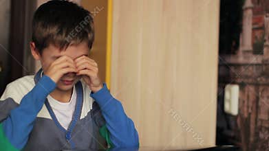 Boy with glasses playing on the computer at home