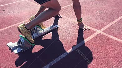 Athlete in Gold Shoes Sprinting Across Starting Line