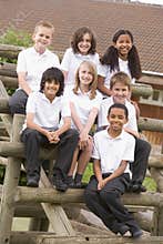 School children sitting on benches outside