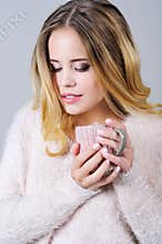 Beautiful woman in pink with a cup of hot tea