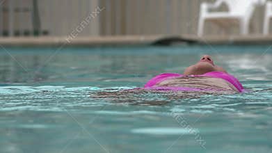 Woman Floating in Swimming Pool
