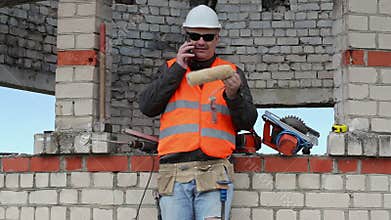 Builder with paint roller talking on smart phone