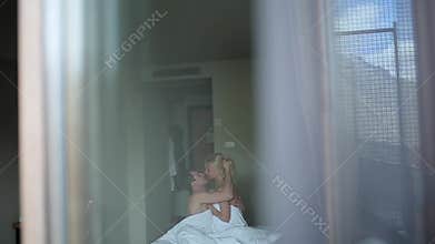Couple embracing lying on their bed