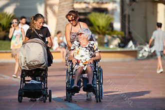 Disabled with wheelchair. Woman with pram. Women generation
