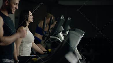 Young people walking on the treadmill smiling