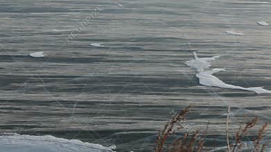 Wind carries sand on the ice of Lake Baikal ice and snow.