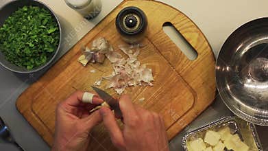Male hands preparing food on a wooden cooking board top view