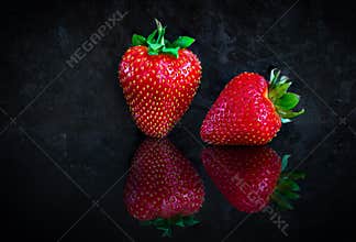 Two strawberries on black background