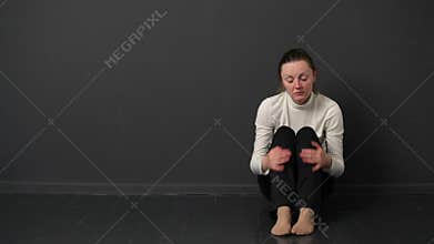 Sad woman is sitting on the floor