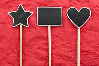 Sign, star, house, heart lie on the red crumpled paper
