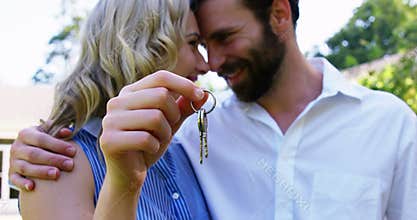 Cute couple looking each other and holding keys