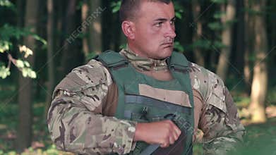 Close up of warrior wears body armor in the forest. Slow motion
